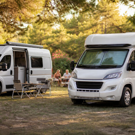 Camping-car et van garés sur un emplacement ombragé d'un camping l'été dans le sud de la France